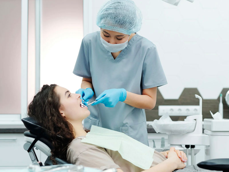 Dentist examining patient’s teeth in Houston dental clinic