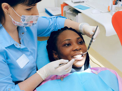 Dentist examining patient’s teeth in Houston dental clinic