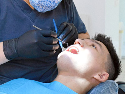 Dentist examining patient’s teeth in Houston dental clinic