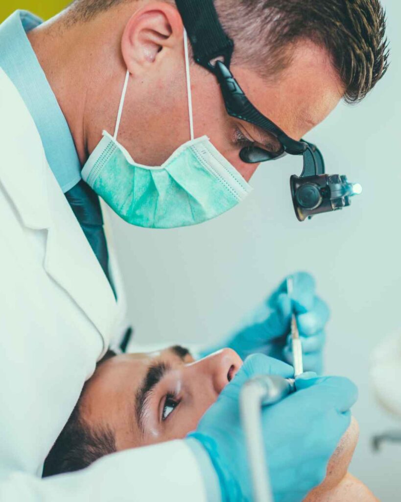 Male dentist examining a patient's tooth before root canal treatment