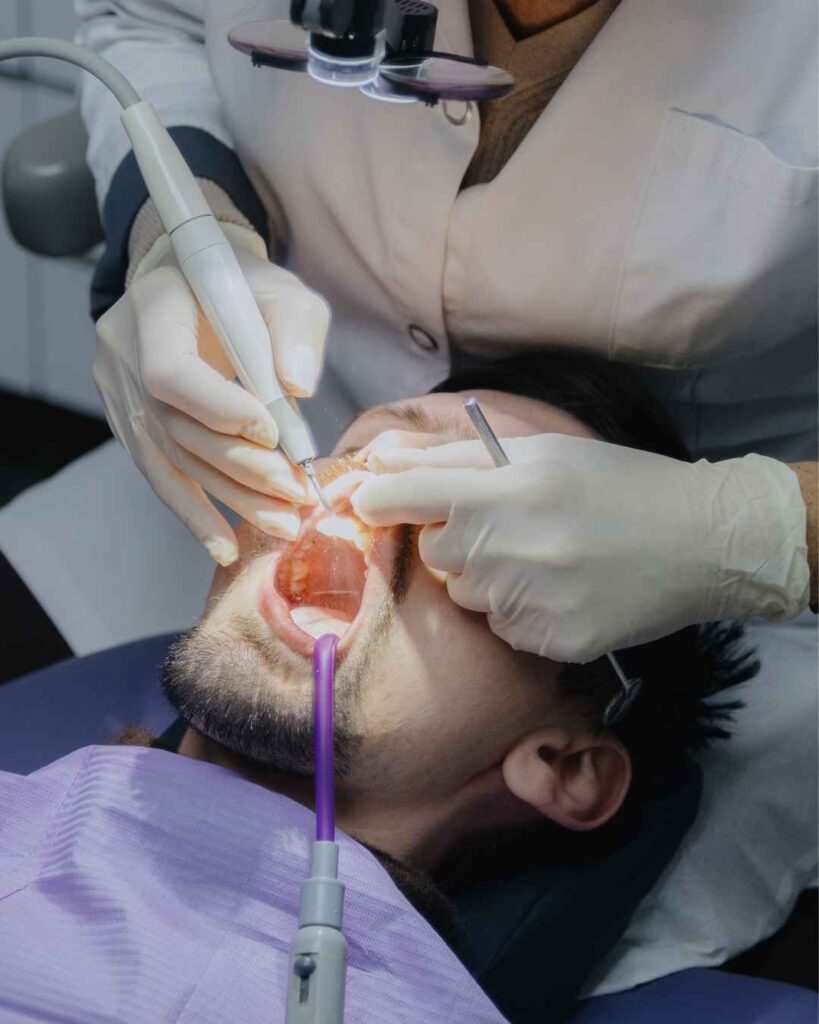 Male dentist performing a root canal treatment procedure on a patient