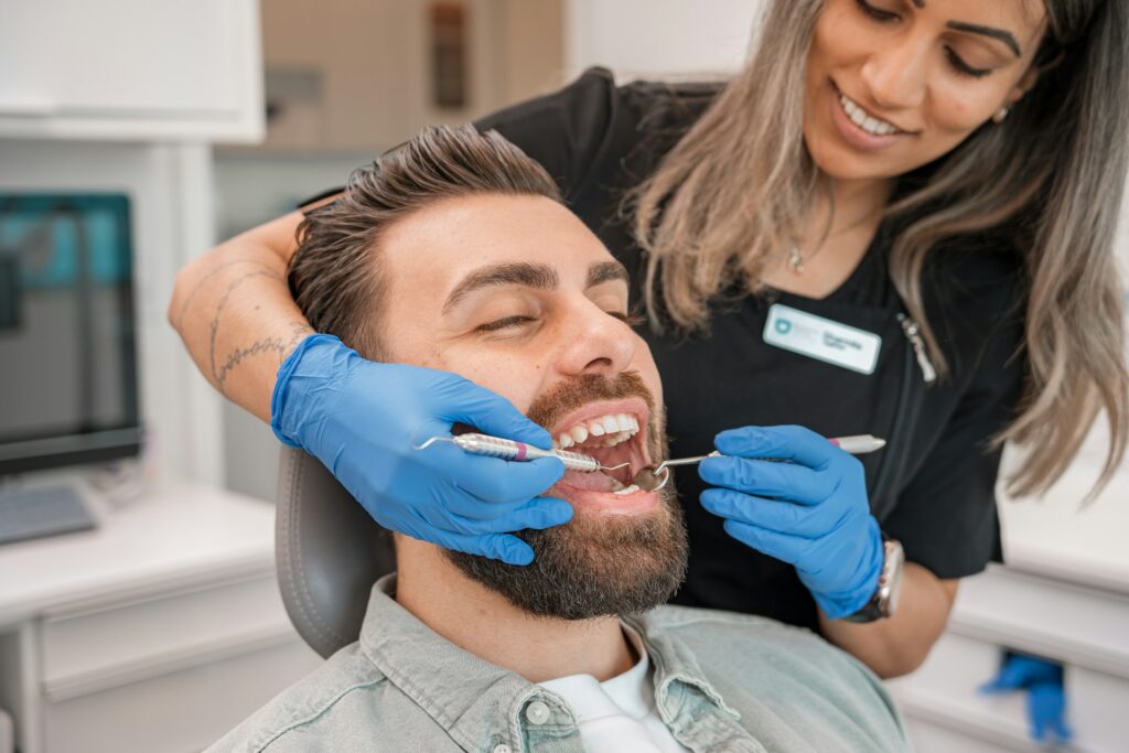 Dentist examining a male patient before teeth whitening treatment